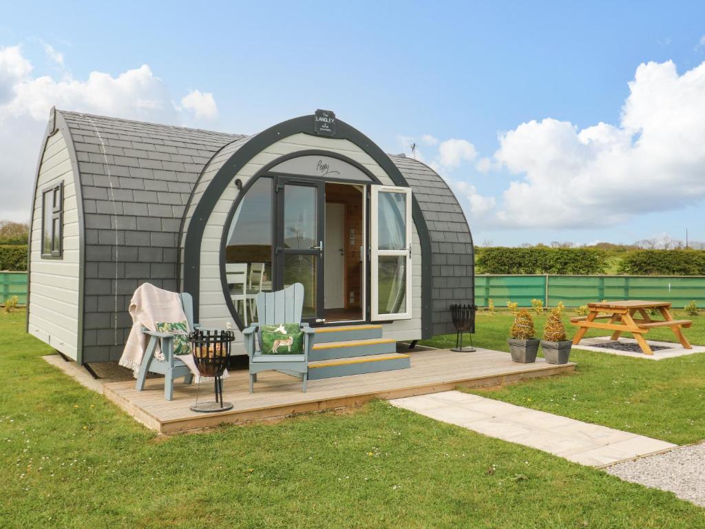 a tiny house with an arched doorway and a deck at Blue Bell in Hull
