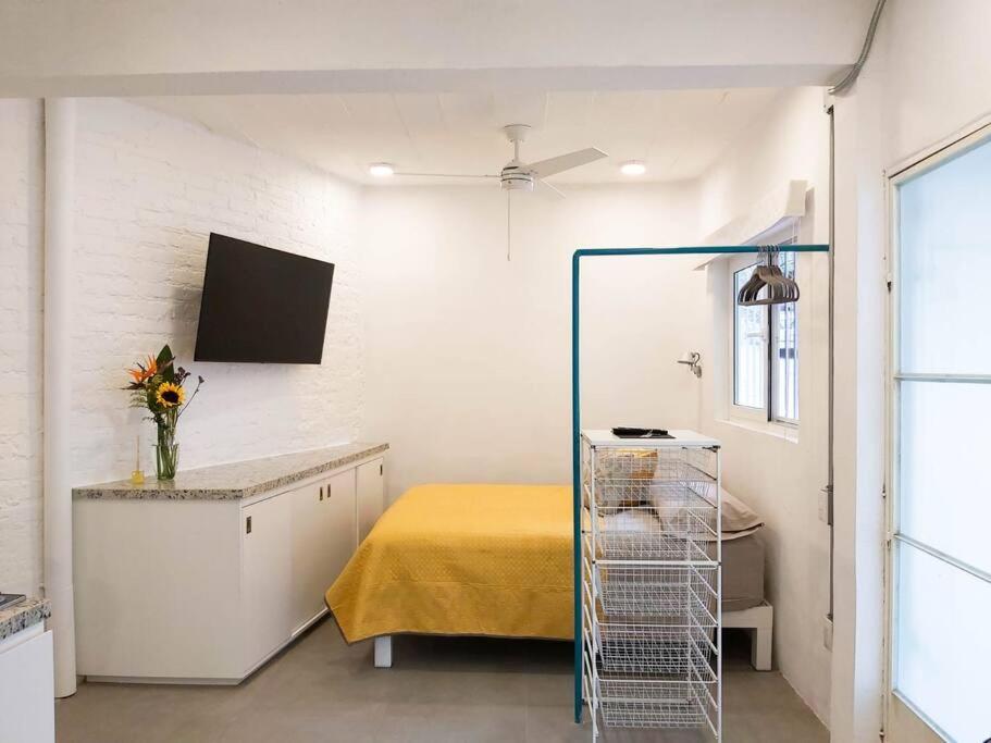 a room with a bed and a yellow table at Studio Pulpito in the charming heart of downtown PV in Puerto Vallarta
