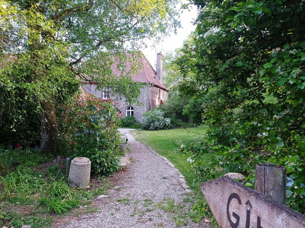 a gravel path leading to a house with a garden at GITE DU MOULIN in Renty