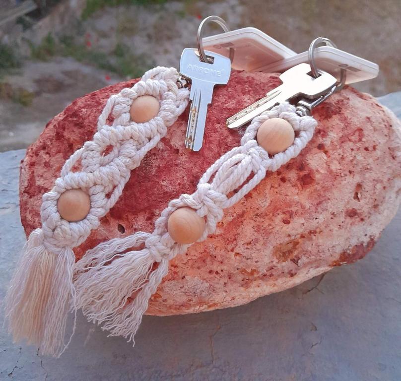 a chain with a key on top of a rock at Salty Caves Apartments Milos in Tripiti