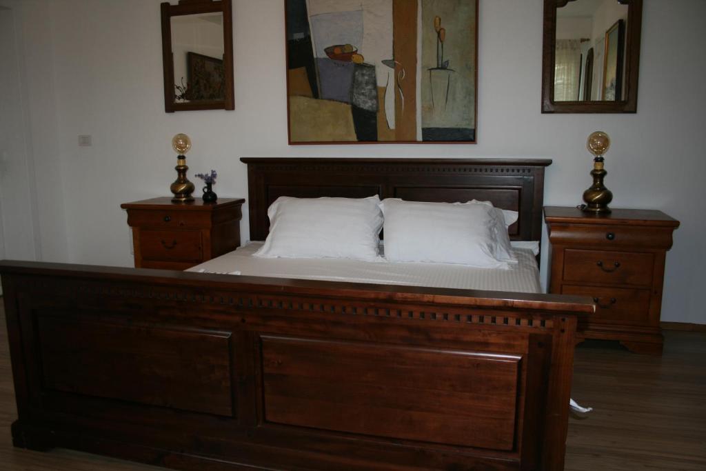 a bedroom with a wooden bed with two dressers at Colev Rooms in Focşani