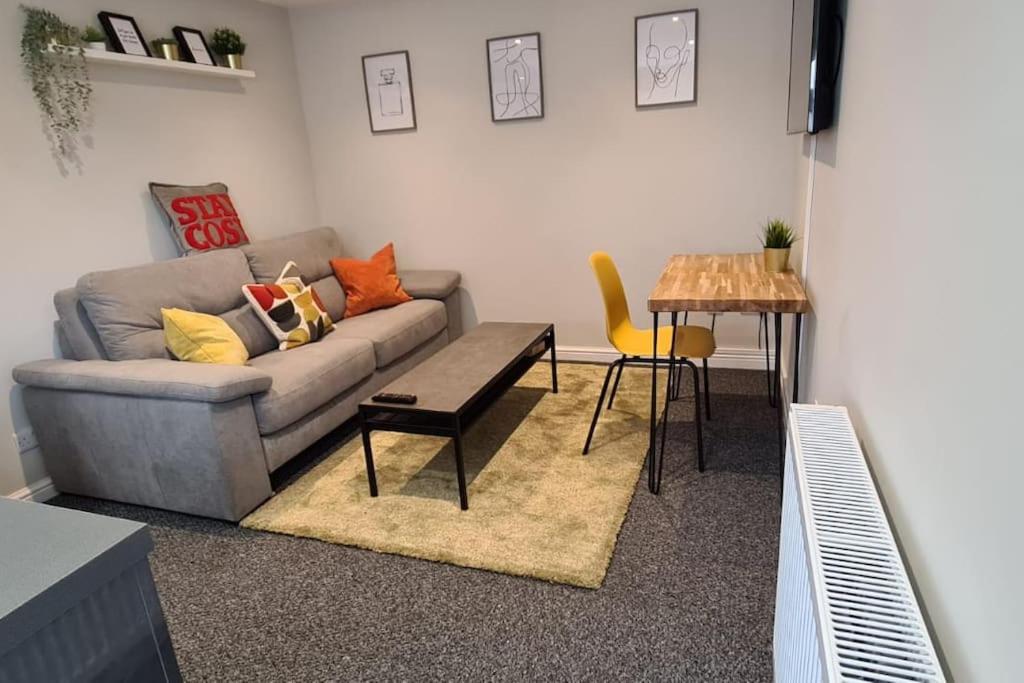 ein Wohnzimmer mit einem Sofa und einem Tisch in der Unterkunft Morris Lodge, Southampton - 1 bedroom, Free WIFI & Parking in Southampton