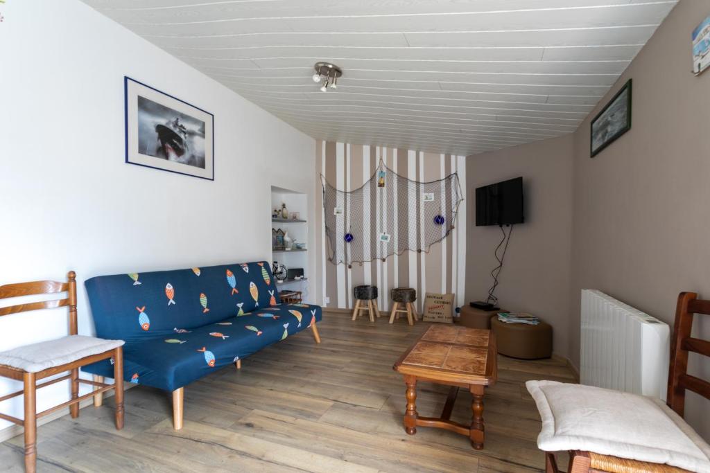 un salon avec un canapé bleu et une table dans l'établissement Le gite de Kergrist, à Le Faouët