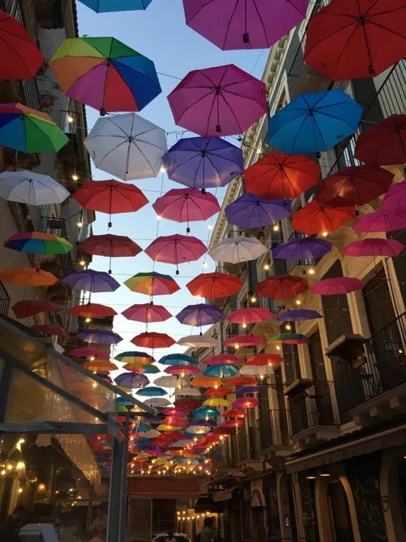 un bouquet de parapluies colorés suspendus au plafond dans l'établissement Zappala' Gemelli House, à Catane