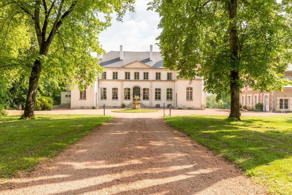 a driveway leading to a large white house with trees at Château de Charmeil- Vichy chambres d'hôtes in Charmeil