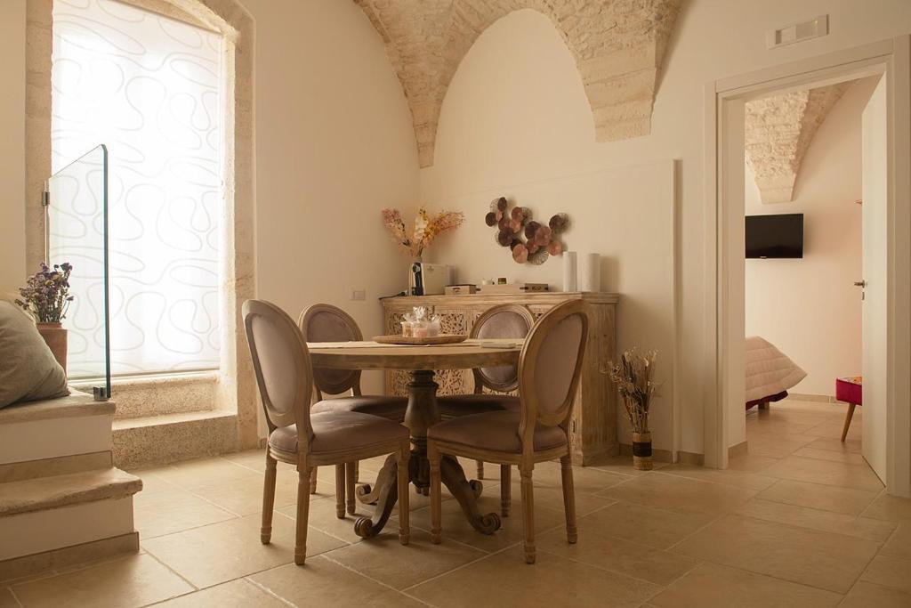 a dining room with a table and chairs at Le mie mani in Martina Franca