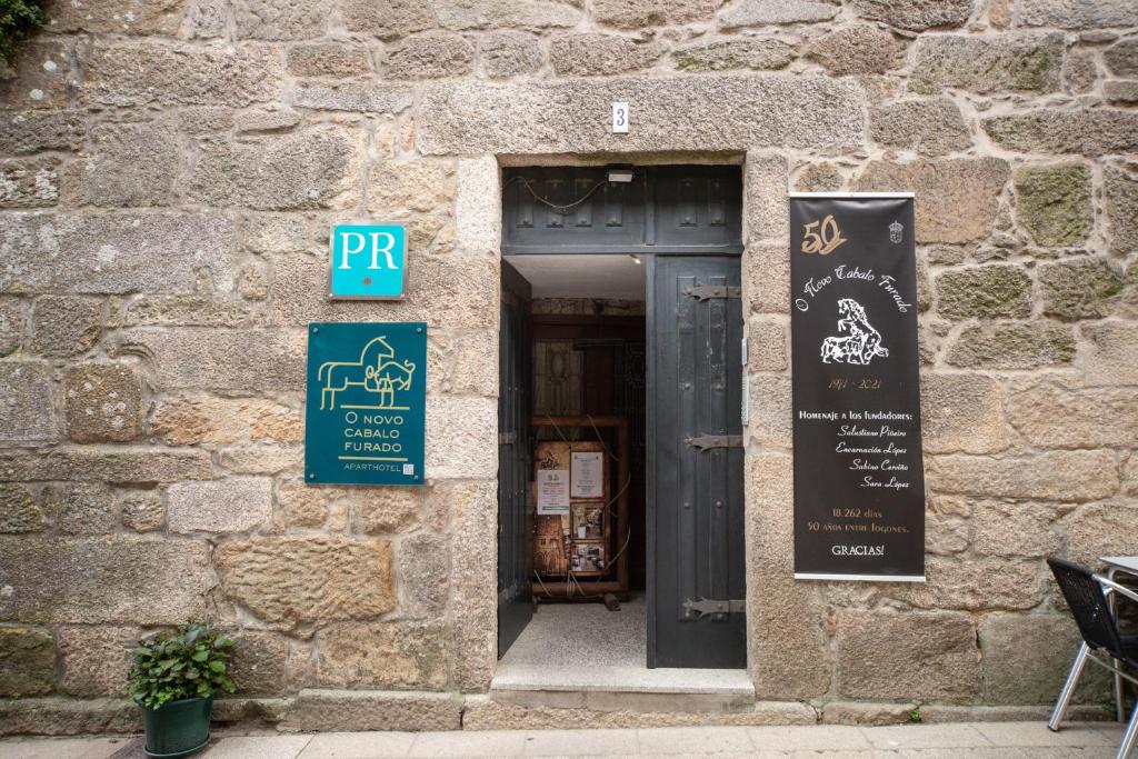 Una puerta a un edificio con un cartel. en Cabalo Furado Tui, en Tui