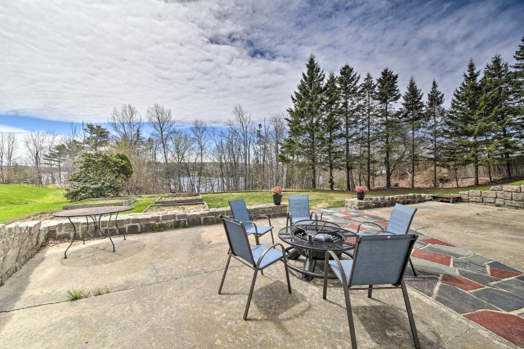 a patio with chairs and a table with a view of a park at Cozy Colonial Home with Bay Access and Water View in Bucksport