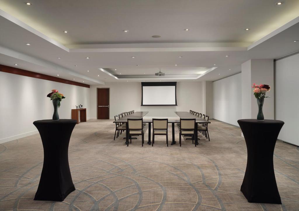 a conference room with a table and chairs and a screen at Hyatt Centric Wall Street New York in New York