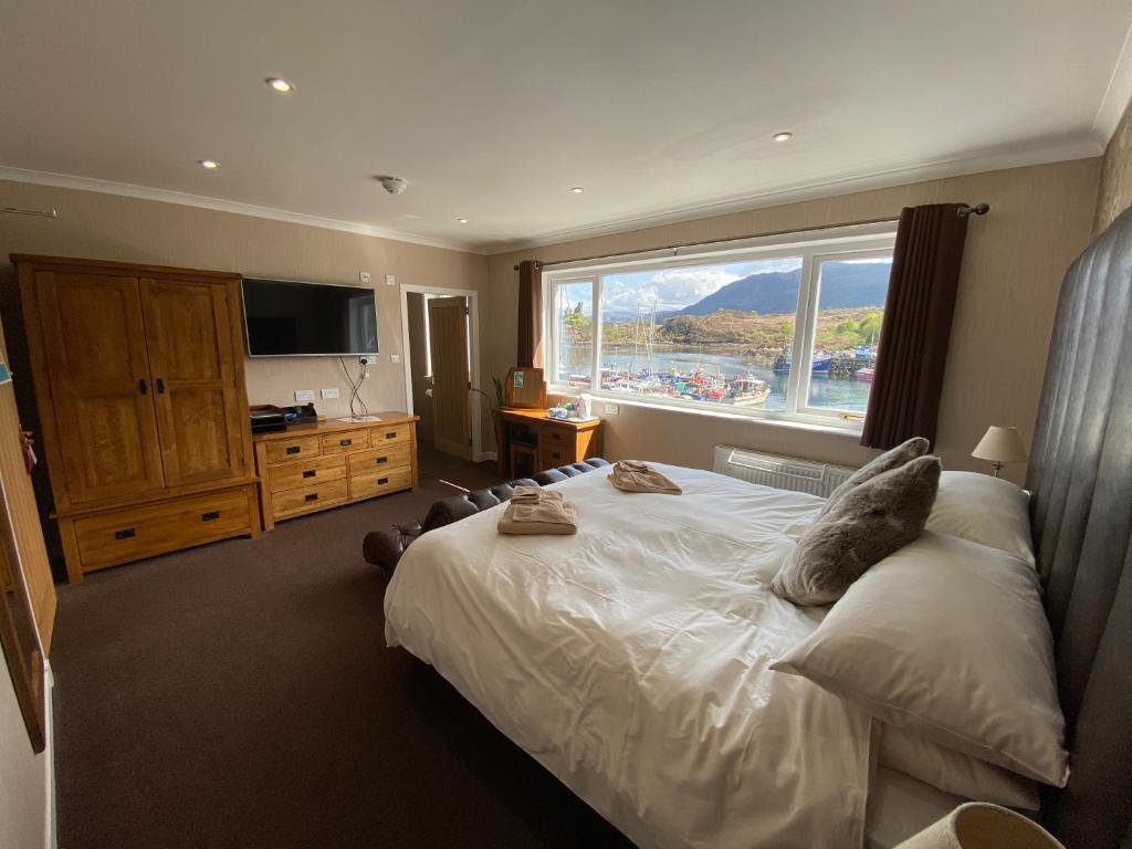 a bedroom with a large bed with a large window at White Heather Hotel in Kyleakin