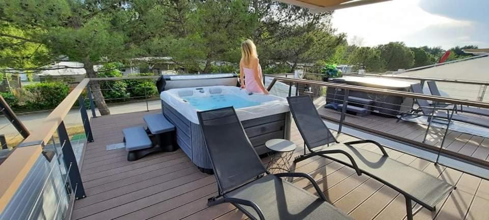 a woman standing on a deck with a hot tub at Floating sea house - VITAL LUX in Portorož