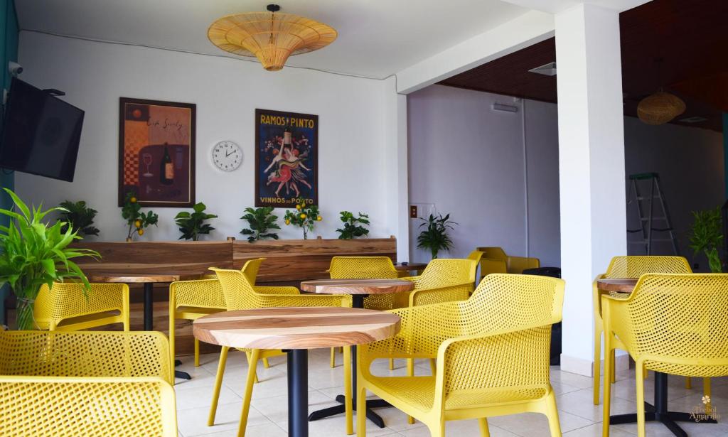 a dining room with yellow chairs and tables at Trebol Amarillo Bed & Breakfast in Escazu