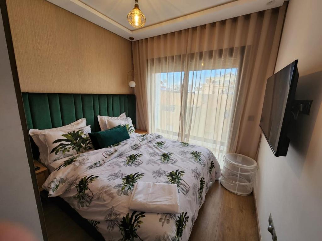 a bedroom with a bed with a green headboard at Appartement Morillon 47 ou 39 au quartier Maarif in Casablanca