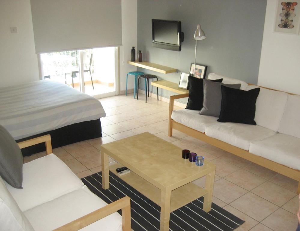 Sala de estar con sofá, cama y mesa en Lykavitos Apartments, en Nicosia