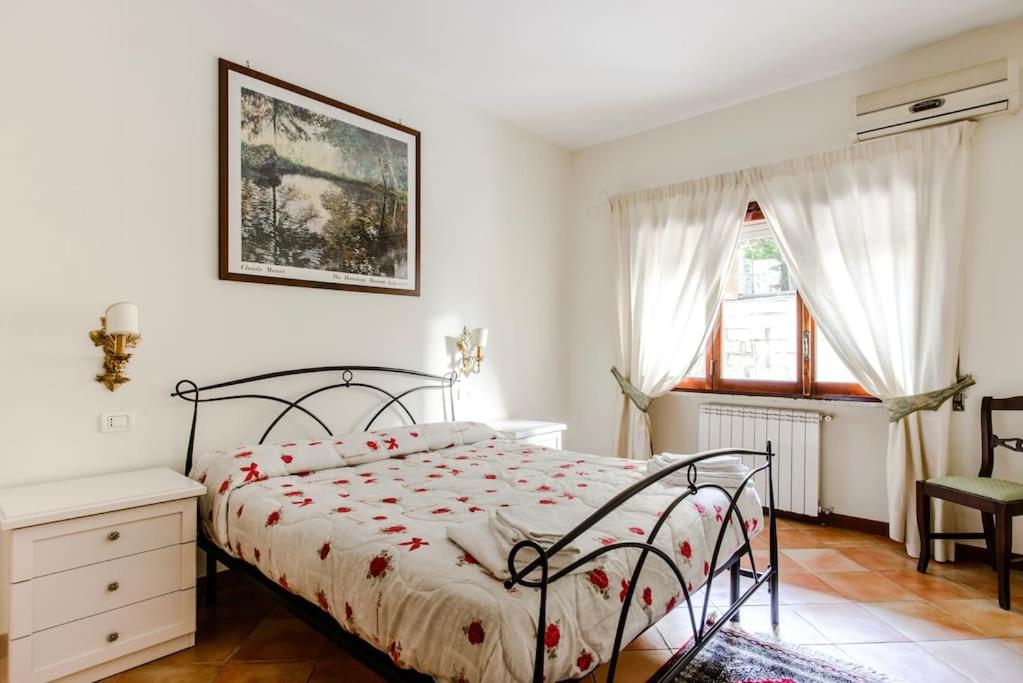 ナポリにあるNapoli Charming Apartments Salvator Rosa "Cool and Sweet" Parking Freeのベッドルーム1室(ベッド1台、椅子、窓付)