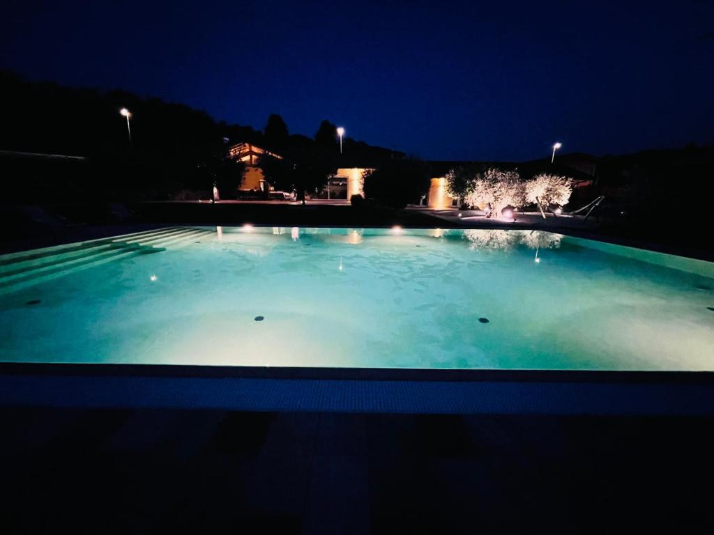 een groot zwembad van blauw water in de nacht bij B&B Alciliegio in Casnate con Bernate