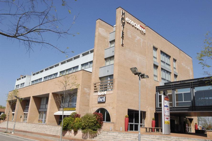 a building with a sign on the side of it at Executive Hotel in Forlì