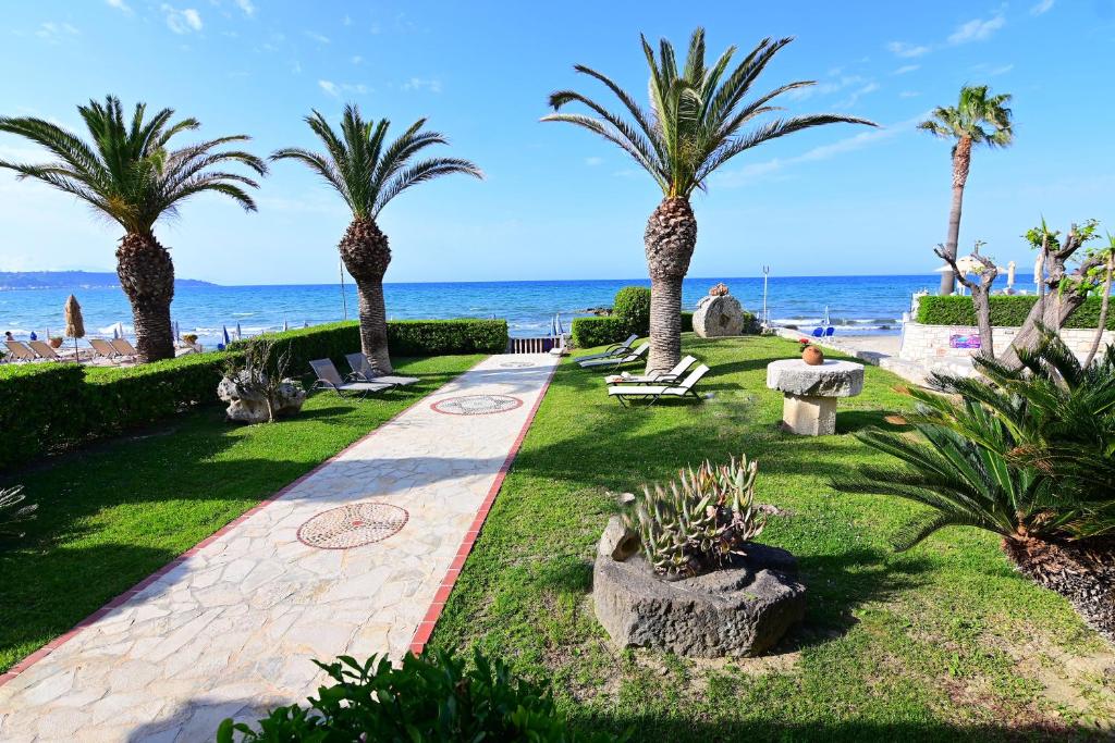 een park met palmbomen en het strand bij Nadia's Studios & Apartments in Argassi