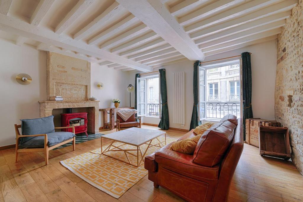 a living room with a couch and a fireplace at Maison de ville Bayeux in Bayeux