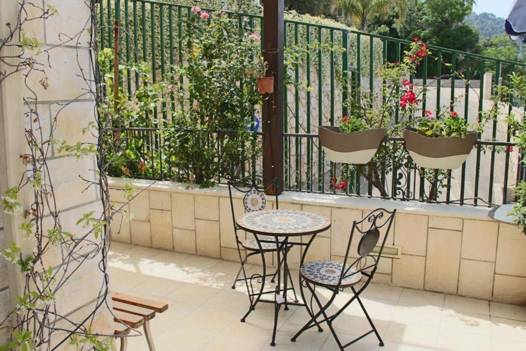 una mesa y sillas en un balcón con plantas en laila's boutique apartment, en Haifa
