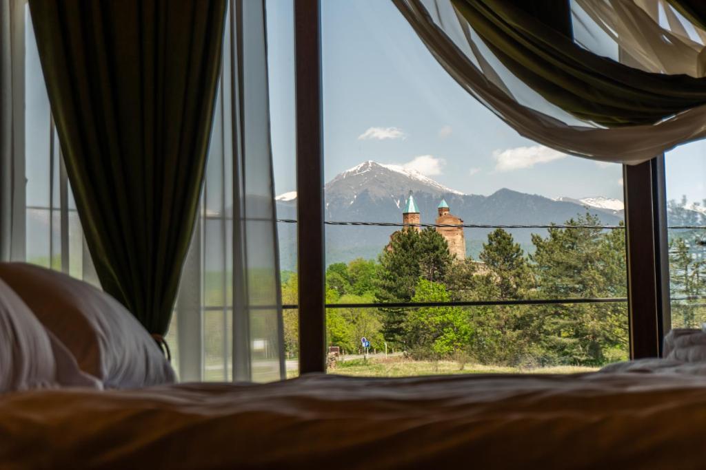 1 dormitorio con ventana y vistas a la montaña en Chateau Gremisio, en Kvareli