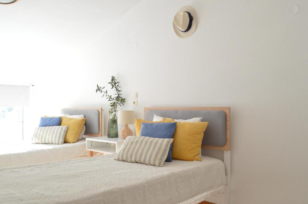 a bedroom with two beds with yellow and blue pillows at Akti Posidonos in Elounda
