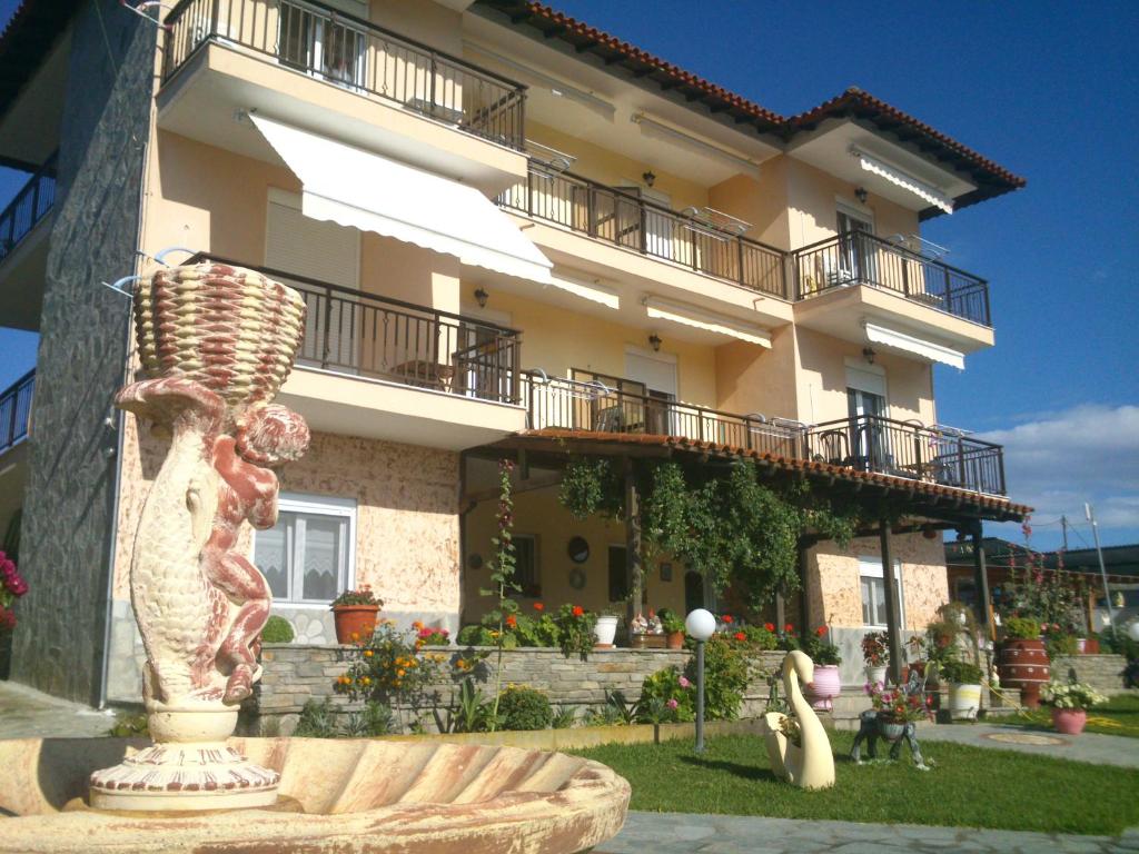 un gran edificio con una estatua delante de él en Sofia & Lakis House en Ormos Panagias