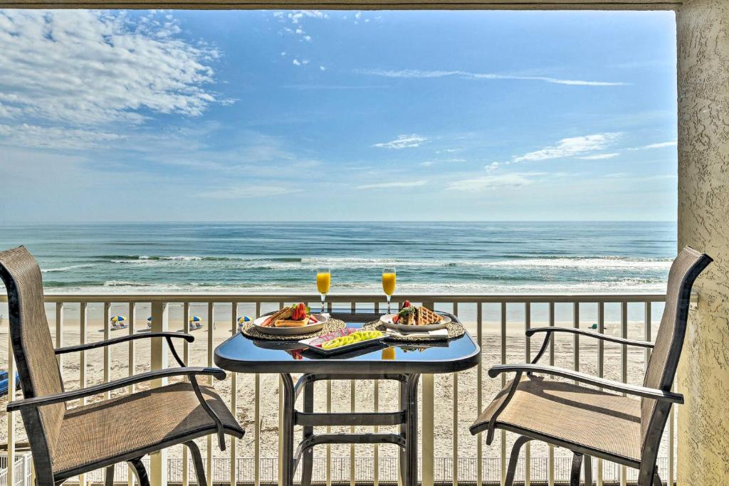 un tavolo con cibo su un balcone con vista sulla spiaggia di Oceanfront, Fourth-Floor Condo on Daytona Beach! a Daytona Beach