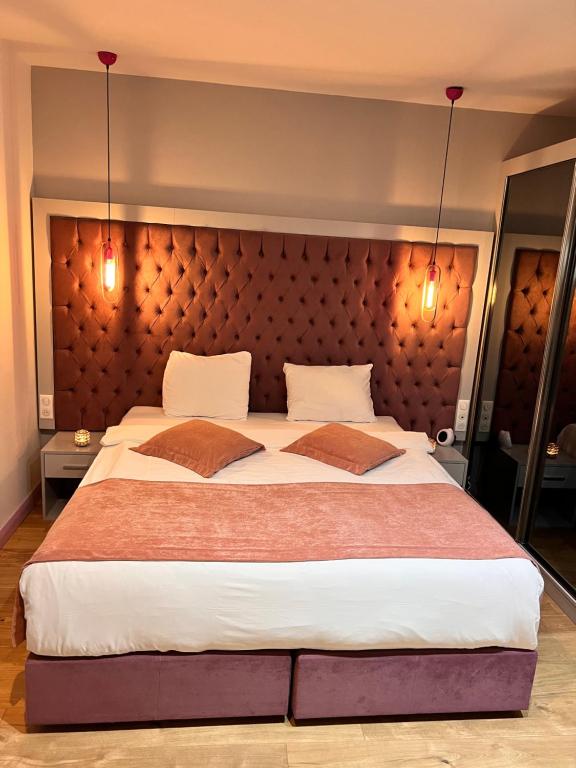 a bedroom with a large bed with a large headboard at Paris Luxury Guest House - CDG Aéroport in Roissy-en-France