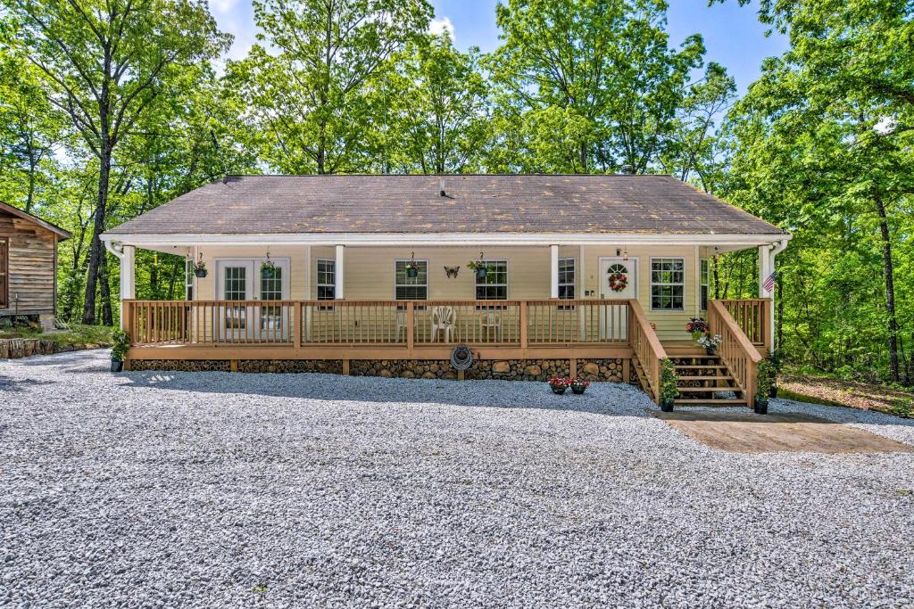 une maison avec une grande terrasse sur une allée de gravier dans l'établissement 9 Mi to Devils Fork State Park Getaway with Porch!, à Salem