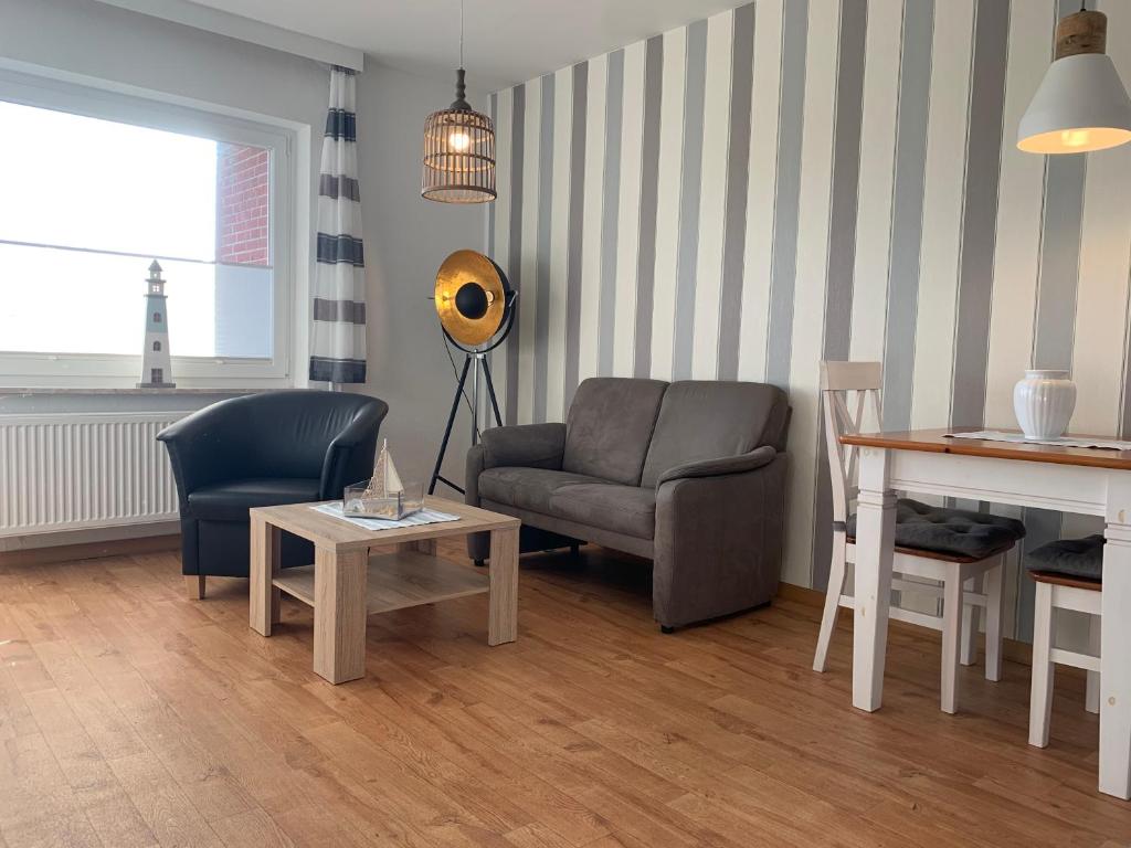 - un salon avec un canapé, une chaise et une table dans l'établissement Kleine Brise Apartment 5, à Büsum