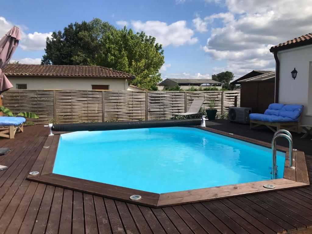 a swimming pool on a deck with a wooden fence at Private bedroom in a guesthouse in Saint Emilion in Saint-Médard-de-Guizières