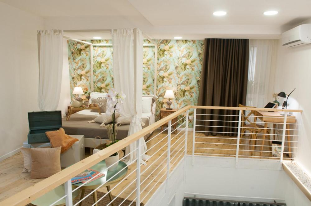 een grote woonkamer met een trap en een woonkamer bij Loft del Teatro in Siracusa