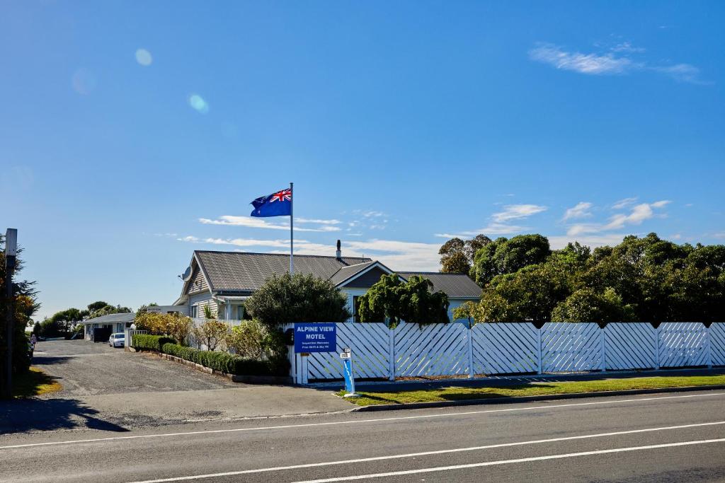 un drapeau battant pavillon au-dessus d'une maison à côté d'une rue dans l'établissement Alpine View Motel, à Kaikoura