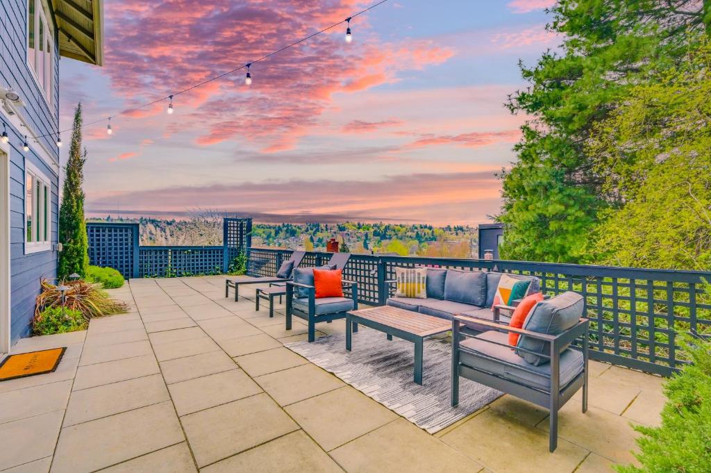 a patio with couches and a table with a sunset at "The Fremont Lookout" with Deck & Gourmet Kitchen! apts in Seattle