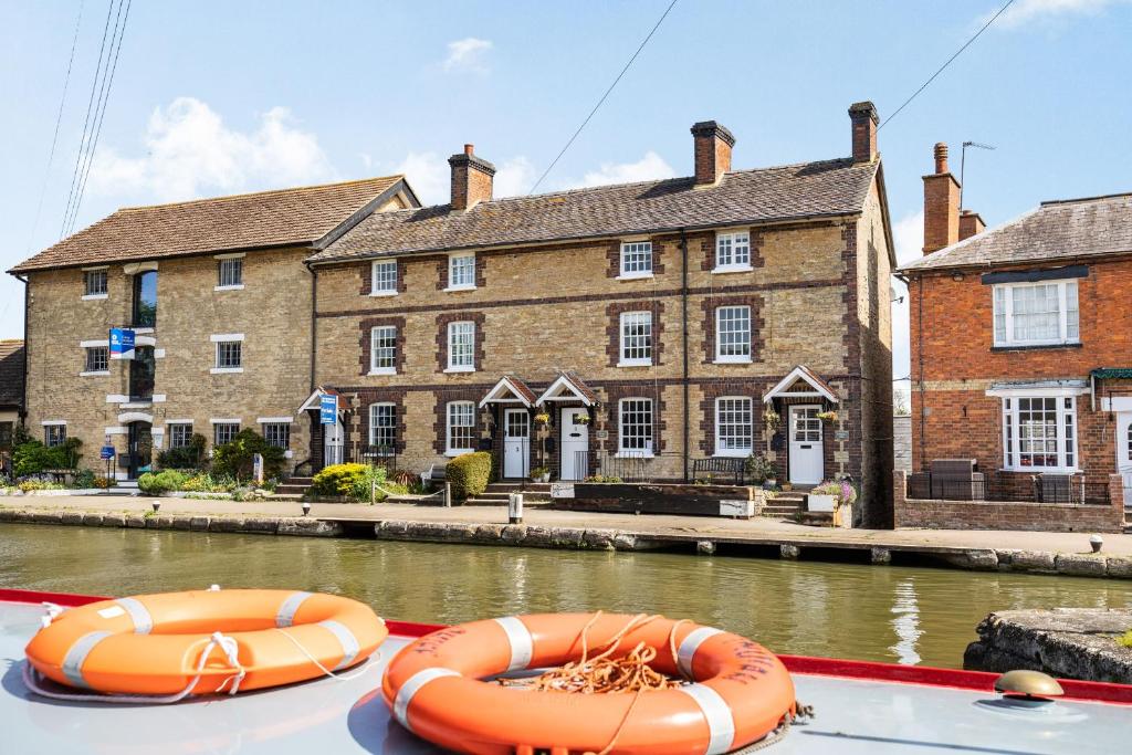 two orange tubes sitting on the back of a boat in a canal at 4 Canalside Cottages in Towcester