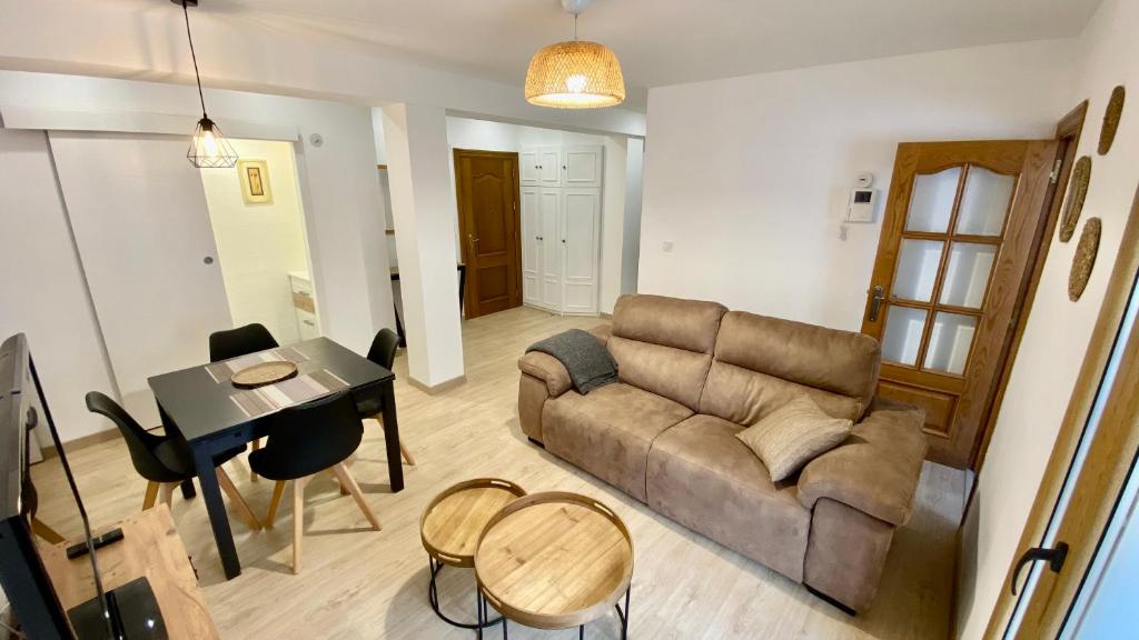 ein Wohnzimmer mit einem Sofa und einem Tisch in der Unterkunft Apartamento Sweet Home Vitoria in Vitoria-Gasteiz