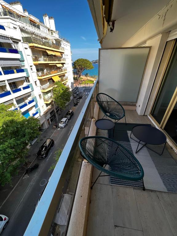 - un balcon avec deux chaises, une table et une rue dans l'établissement Modern 60m2 apartment with 2 balconies, at 50 meters from sea, à Antibes
