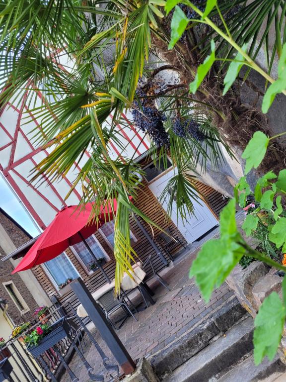 a tree with a red umbrella and tables and chairs at Ferienhaus Larina in Cochem