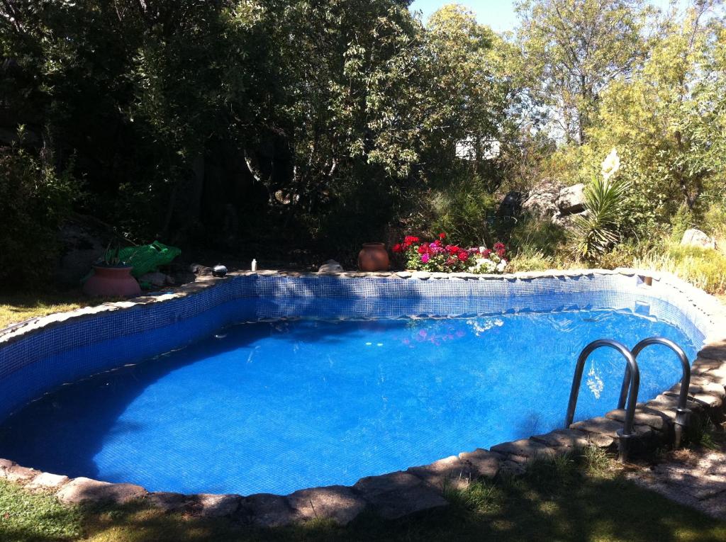 a large blue swimming pool in a yard at Casa Rural Saint Joseph in Peralejo