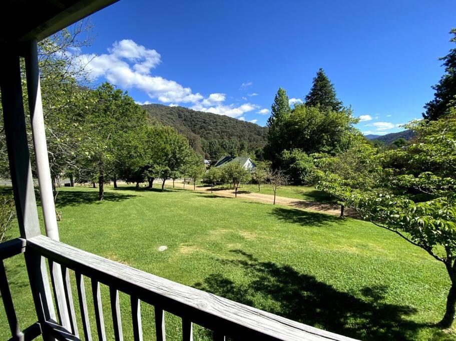 balcón con vistas a un campo de césped en Crabapple Cottage Harrietville, en Harrietville