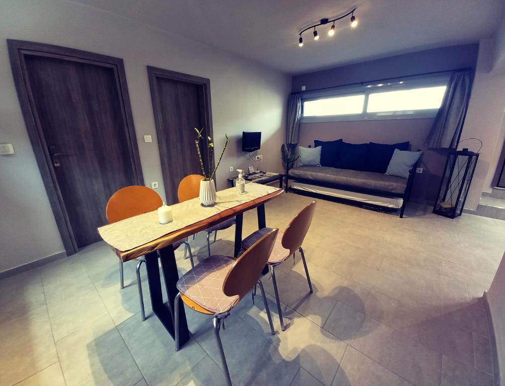 sala de estar con mesa, sillas y sofá en Etoile apartment en Perissa