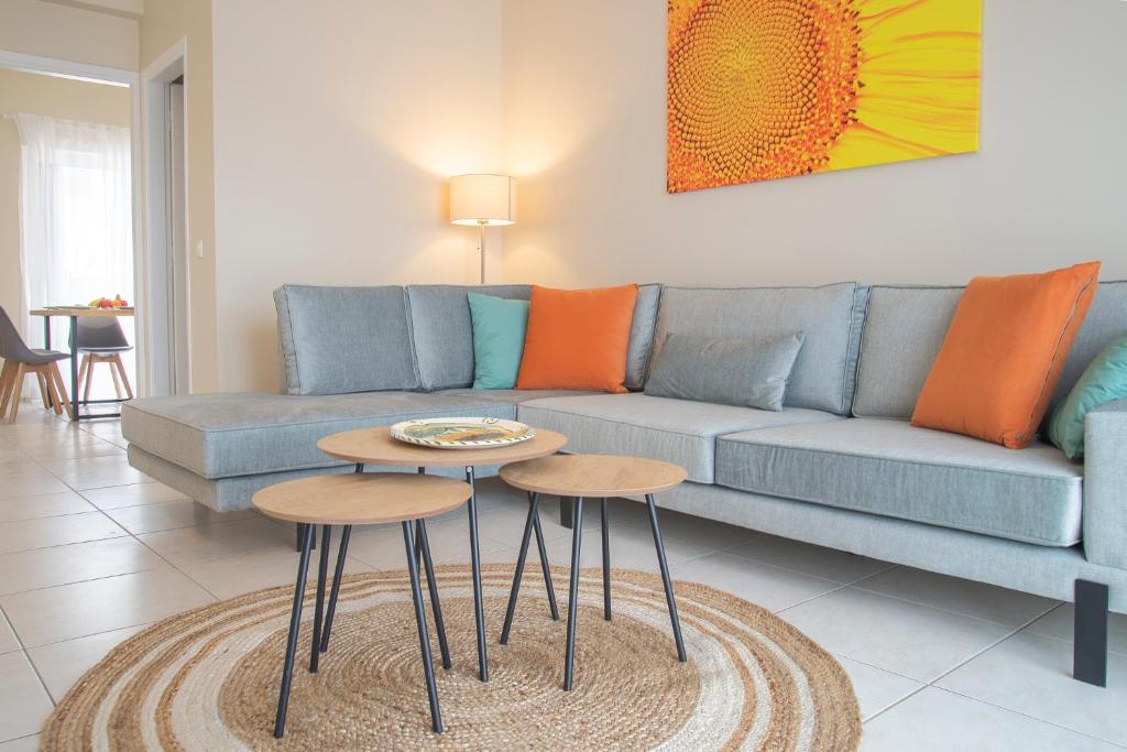 uma sala de estar com um sofá e duas mesas em Helios: Charming beach home next to crystal waters em Nea Makri
