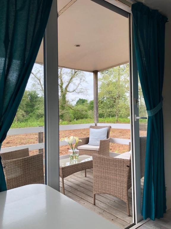 une chambre avec un balcon avec une table et des chaises dans l'établissement gite mobil landes, à Mano