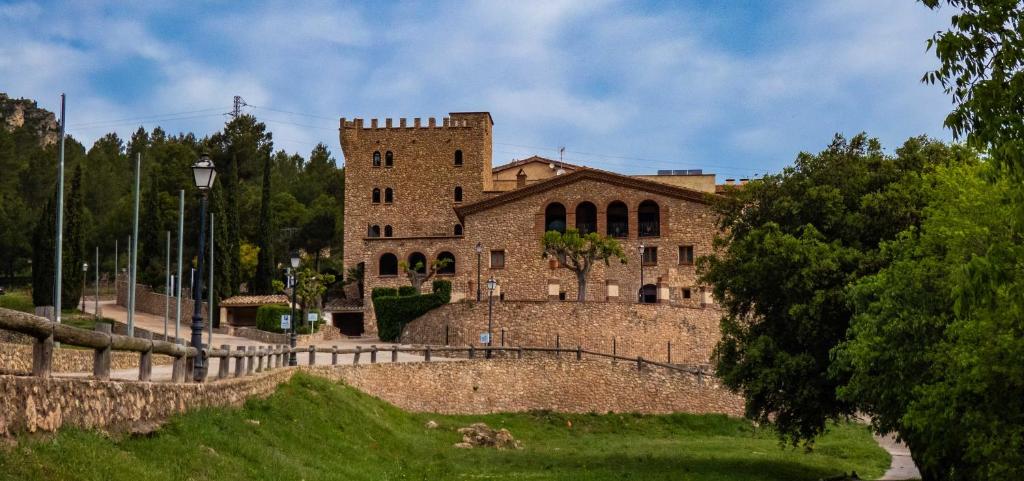 um grande edifício de tijolos em frente a uma parede em La Figuerola Hotel & Restaurant em Vandellós