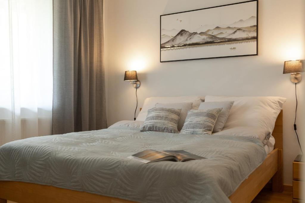 Fresh Apartment with Terrace + Free Parking في غراتس: غرفة نوم بها سرير مع كتاب عليها