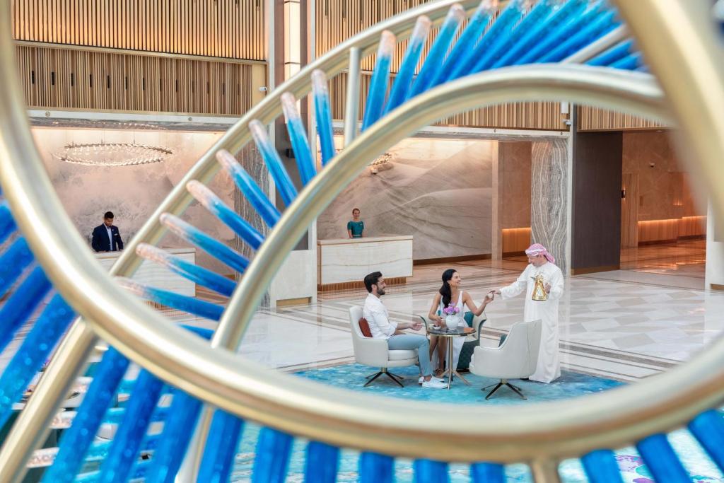 a group of people sitting at a table in a building at Taj Exotica Resort & Spa, The Palm, Dubai in Dubai