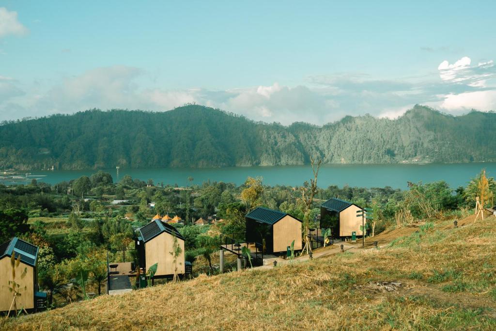 un groupe de cabanes sur une colline à côté d'un lac dans l'établissement Bobocabin Kintamani, Bali, à Kintamani