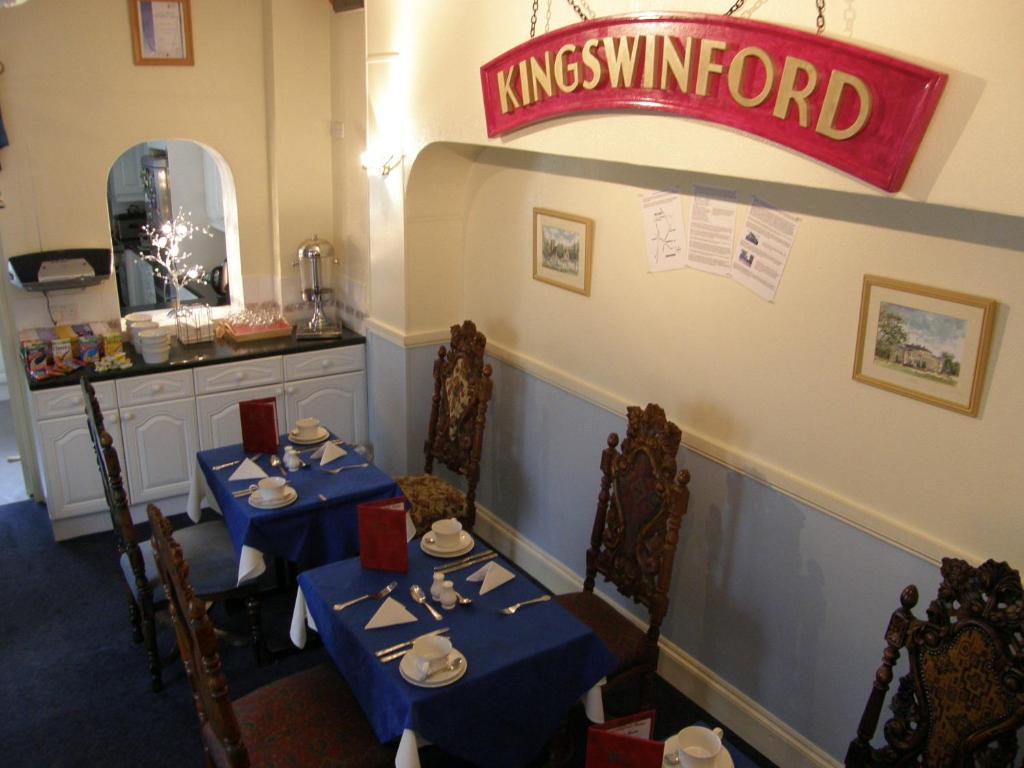 un comedor con 2 mesas y un cartel de kingskunnd en Kingswinford Guest House, en Paignton