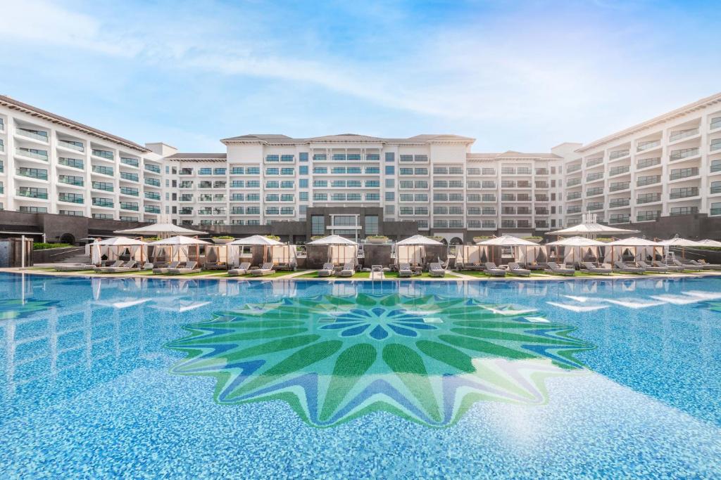 a large hotel with a large swimming pool with umbrellas at Taj Exotica Resort & Spa, The Palm, Dubai in Dubai